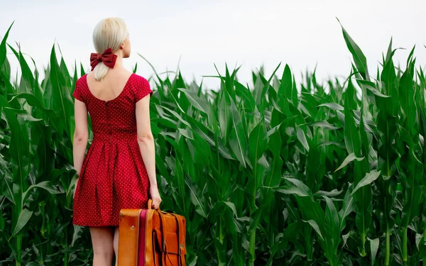 ブロンド女性で美しい赤いドレスとともにスーツケースでコーンフィールド — ストック写真
