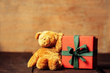 Oyuncak ayı ve bayram hediyesi ahşap masa arkaplanında. Klasik renk biçimi