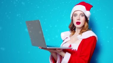 Dizüstü bilgisayarı olan kırmızı elbiseli Noel Baba kızı. Canlandırılmış kar yağışı videosu