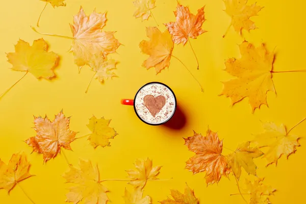 Kopp Kaffe Med Hjärtform Och Lönnlöv Runt Gul Bakgrund — Stockfoto