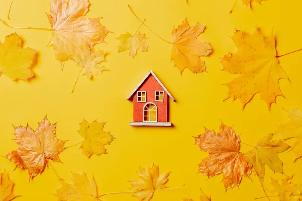 Kleines Spielzeughaus Und Ahornblätter Auf Gelbem Hintergrund Ansicht Von Oben — Stockfoto