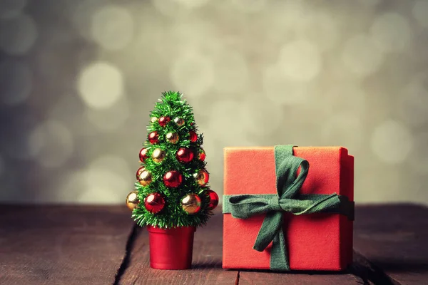 木のテーブルの上にクリスマスツリーと赤のギフトボックスにボケを背景に — ストック写真