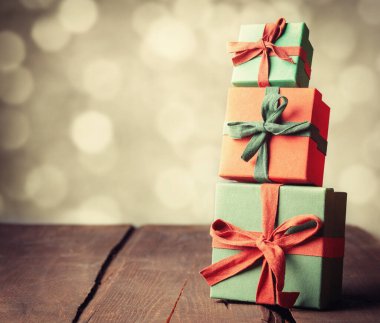 Ahşap masada arka planda bokeh olan klasik kırmızı hediye kutuları..