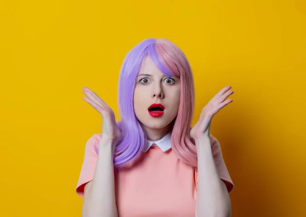 紫の髪と黄色の背景にピンクのドレスを持つ女の子 — ストック写真