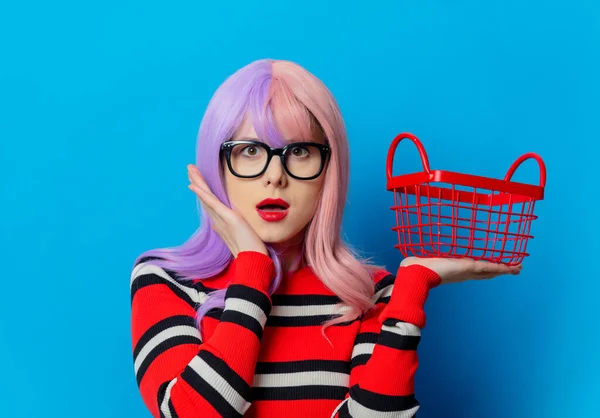 Lila Hajú Lány Piros Pulóverrel Bevásárlókosárral Kék Háttérrel — Stock Fotó