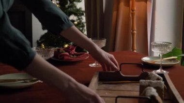 Bir kadının Noel yemeği için nasıl masa hazırladığını.