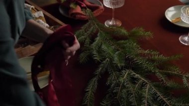 Bir kadının Noel yemeği için nasıl masa hazırladığını.