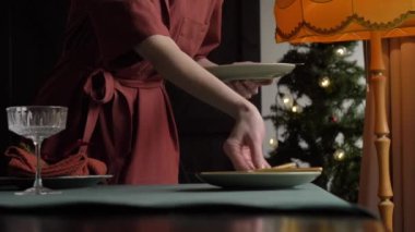 Bir kadının Noel yemeği için nasıl masa hazırladığını.