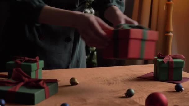 テーブルの上でクリスマスのプレゼントや郵便物を用意する女性は — ストック動画