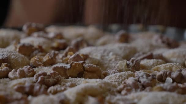女性は家のテーブルでナッツパイに砂糖を振りかける — ストック動画
