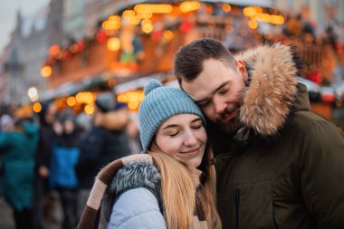 Güzel bir çift, erkek arkadaş ve kız arkadaş Wroclaw, Polonya 'da Noel fuarında öpüşüyor.