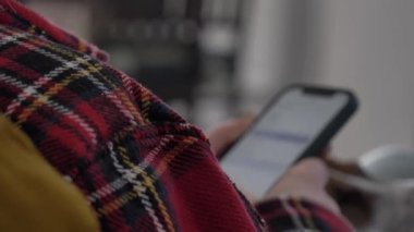 İnternette cep telefonuyla gezinen bir kadın.