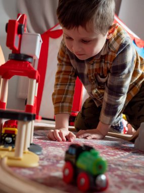 Küçük çocuk evdeki trende oynuyor. 