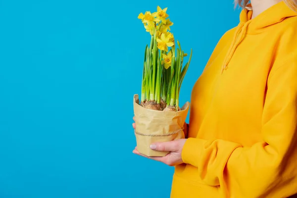 Elegante Femmina Felpa Gialla Con Fiori Narciso Sfondo Blu — Foto Stock