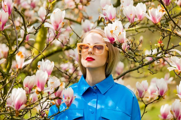 Stylowa Kobieta Okularach Niebieskiej Koszuli Pobliżu Drzewa Magnolia Wiosnę — Zdjęcie stockowe