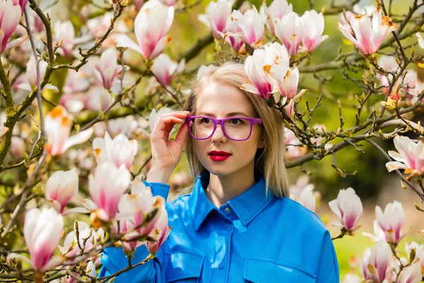 Stijlvolle Vrouw Bril Blauw Shirt Buurt Van Magnolia Boom Het — Stockfoto