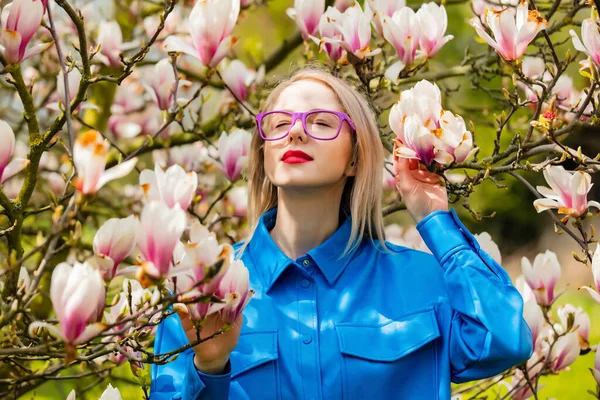 Snygg Kvinna Glasögon Och Blå Skjorta Nära Magnolia Träd Våren — Stockfoto