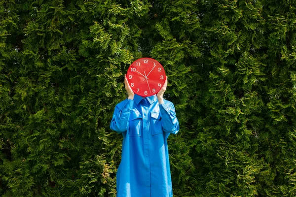 Elegante Donna Camicia Blu Tenere Orologio Rosso Sfondo Alberi Verdi — Foto Stock