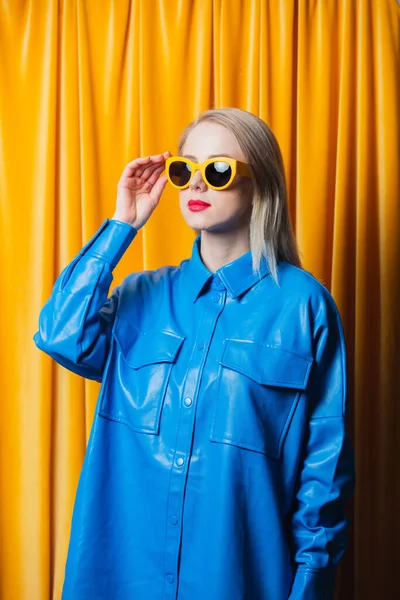 Mavi gömlekli şık Ukraynalı kadın ve sarı perdeli sarı gözlüklü arka plan