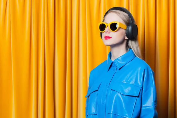 Stylish Woman Blue Shirt Yellow Sunglasses Music Headphones Yellow Curtain — Fotografia de Stock