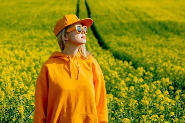 Stylish Woman Yellow Hoodie Cap Sunglasses Rapeseed Field — 스톡 사진