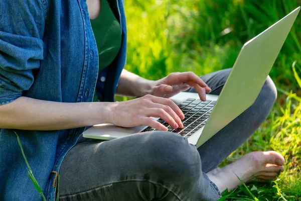 Bahçede bilgisayarla çalışan bir kadın geliştirici.