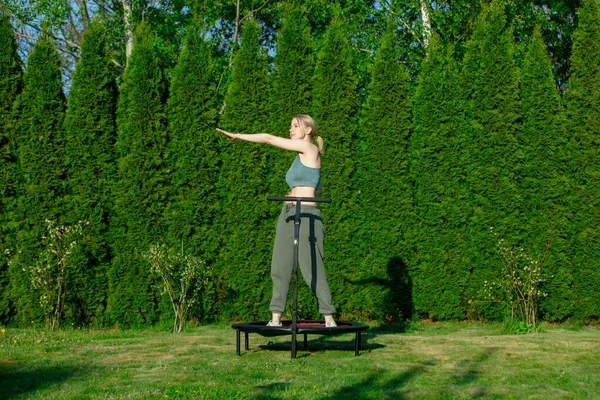 Dívka Dělá Skákání Fitness Trampolíně Přírodě Zelené Trávě Stromy Pozadí — Stock fotografie