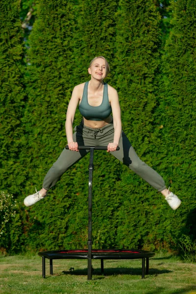 Dívka Dělá Skákání Fitness Trampolíně Přírodě Zelené Trávě Stromy Pozadí — Stock fotografie