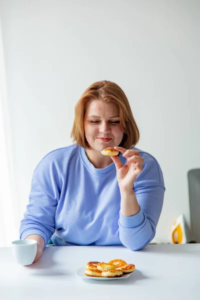 Ukraynalı Göçmen Kadın Kahvaltıda Elinde Fincan Peynirli Kekle Masada Oturuyor — Stok fotoğraf