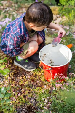 Küçük çocuk baharda bahçede oynuyor.