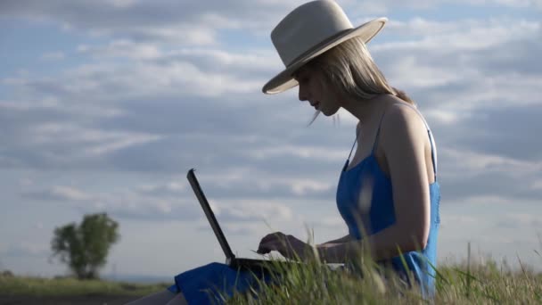 带着手提电脑的妇女坐在乡村路上 — 图库视频影像