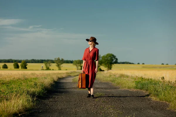 Ragazza Abito Rosso Con Valigia Sulla Strada Campagna Tramonto — Foto Stock