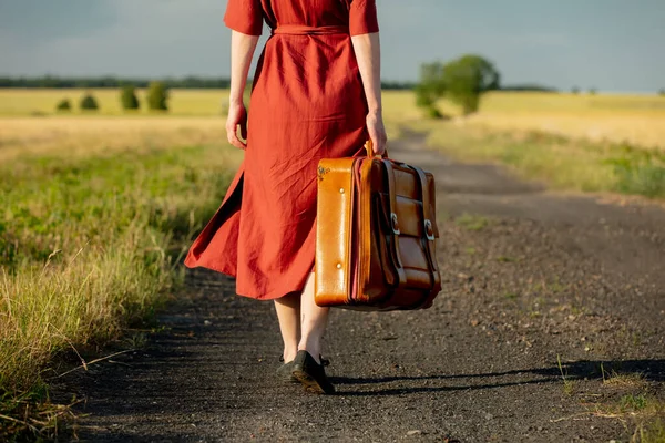 Mädchen Roten Kleid Mit Koffer Auf Der Landstraße Sonnenuntergang Schlechte — Stockfoto