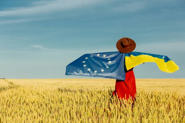 与乌克兰和欧盟国旗的女孩 背景是麦田和蓝天 — 图库照片