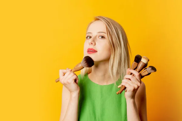 Stylish Girl Green Dress Makeup Brushes Yellow Background — Stockfoto