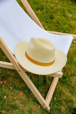 Wooden chair and hat in a garden