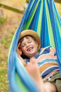 Mutlu çocuk yaz bahçesinde hamakta