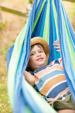 Mutlu çocuk yaz bahçesinde hamakta