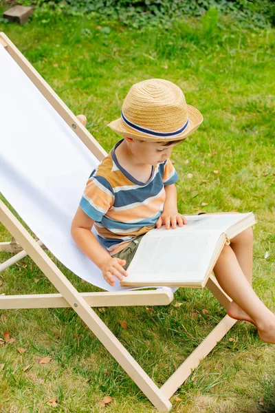 Funny Little Boy Book Sits Chair Outdoor — Stockfoto