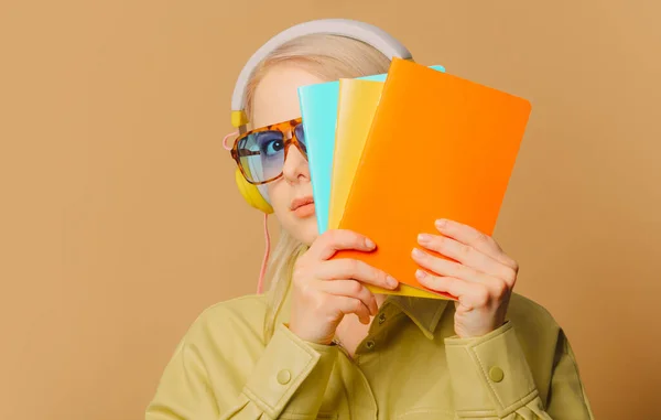 Stylish 80S Woman Eyeglasses Headphones Notebooks Brown Background — Stockfoto
