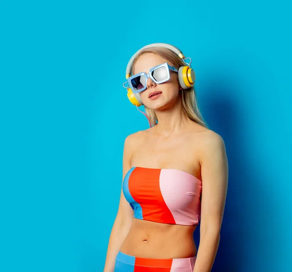 Stylish Blond Woman Colored Swimming Suit Headphones Sunglasses Blue Background — Stockfoto
