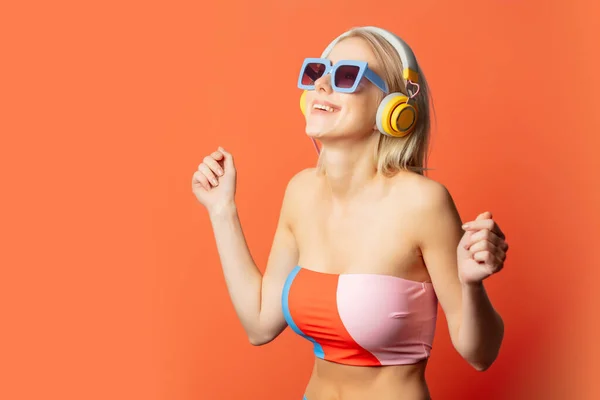 Stylish Blond Woman Colored Swimming Suit Headphones Sunglasses Orange Background — 图库照片