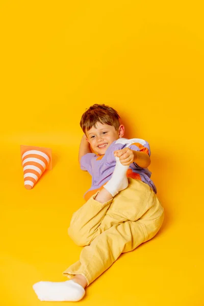 Stylish Little Boy Lying Yellow Background — Zdjęcie stockowe