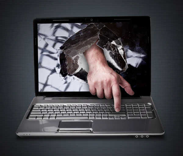 CONCEPT laptop with with broken screen the hand presses the button — Stock Photo, Image