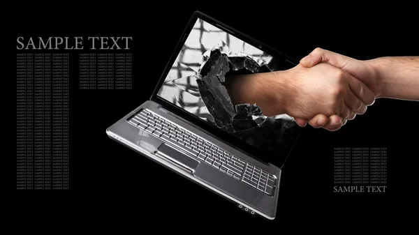 A hand comes right out of the laptop screen to shake hands — Stock Photo, Image