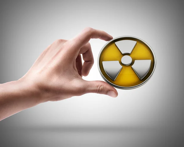 Man's hand holding radiation sign — Stock Photo, Image