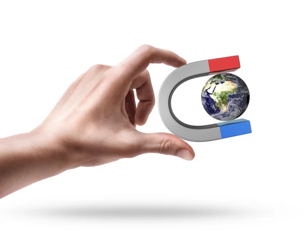 Man's hand holding Magnet and Earth — Stock Photo, Image