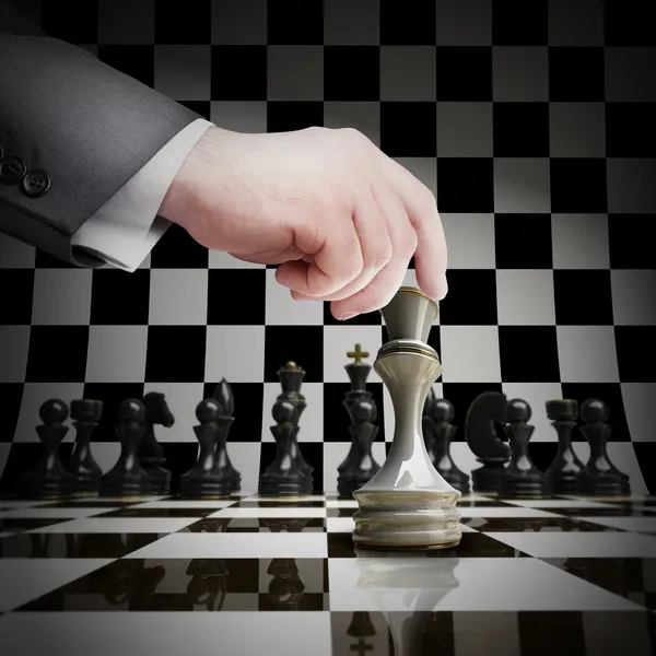 Hand hält weiße Schachfigur auf Schachbrett — Stockfoto