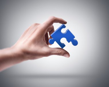 Hand holding blue puzzle clipart
