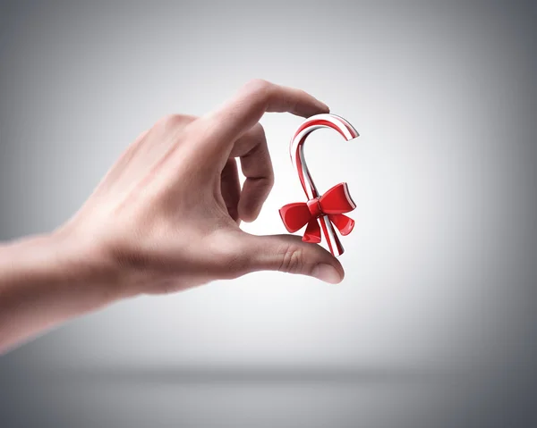 人間の手お菓子甘いと赤の弓 — ストック写真